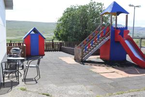 un parco giochi con scivolo, tavolo e sedie di Grímsstaðir holiday home - Family friendly a Reykholt