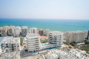 eine Luftansicht einer Stadt mit Gebäuden und dem Meer in der Unterkunft Seaview Pearl Suite Larnaca in Larnaka