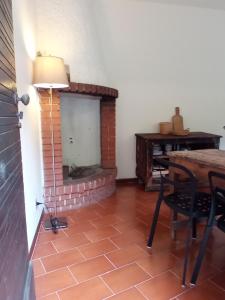 uma sala de estar com uma lareira de tijolos e uma mesa em Ai Grilli - Ospitalità e natura em Casto