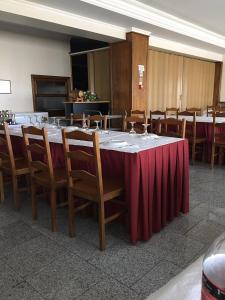 einen großen Tisch mit einem roten Tischtuch und Stühlen in der Unterkunft Autentisereia in Algoso