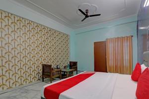 Super OYO Flagship Siddharth Inn في لاكناو: غرفة نوم بسرير ومروحة سقف