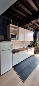 a kitchen with white cabinets and a microwave at The 16th Century 2BR Apartment in The City Center in Antwerp