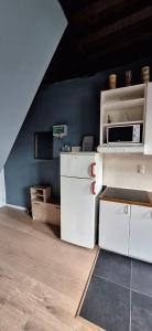 a kitchen with white cabinets and a microwave at The 16th Century 2BR Apartment in The City Center in Antwerp