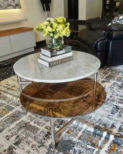 a glass coffee table with books and a vase of flowers at Peniel Place in Makurdu