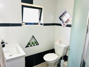 a bathroom with a white toilet and a sink at דרך עצי הזית - through the olive tree in Neve Ilan