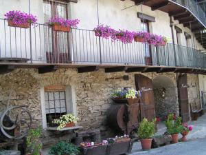 un edificio con macetas de flores en un balcón en Maison Mariot, en Roure Turin