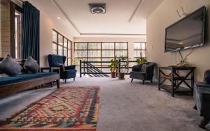sala de estar con TV de pantalla grande y sillas en Offto Resort Hunza, en Hunza
