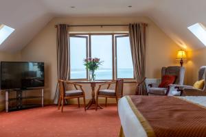 um quarto de hotel com uma mesa e uma grande janela em Waterfront House & Restaurant em Enniscrone