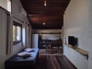 a living room with a bed and a kitchen at Casas Porto Belo, um recanto a 100 metros da praia in Porto Belo