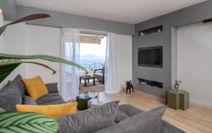 Varkiza Sea Front Residence في فاري: غرفة معيشة مع أريكة وتلفزيون