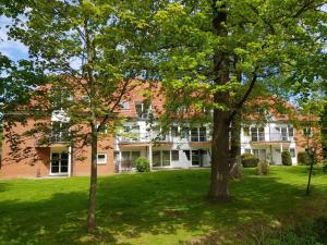 a large brick building with trees in the yard at Auszeit am Meer - a73607 in Bastorf