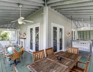 um alpendre com uma mesa de madeira e cadeiras numa casa em Casa di Spiaggia Tybee em Tybee Island