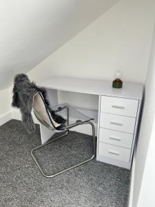 einen weißen Schreibtisch mit einem Stuhl darunter mit einer Feder in der Unterkunft 2 bedroom flat in London