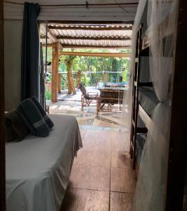 a bedroom with a bed and a patio with a table at Sitio Simple Life in Ubatuba