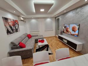 uma sala de estar com um sofá e uma televisão de ecrã plano em Arena Lux em Novi Beograd