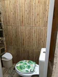 a bathroom with a toilet and a wooden wall at Sitio Simple Life in Ubatuba