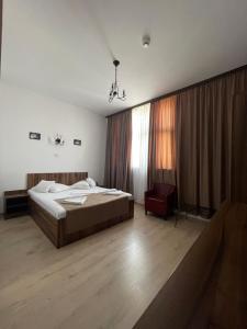 アルバ・ユリアにあるHotel Prestigeのベッドルーム1室(ベッド1台、椅子付)