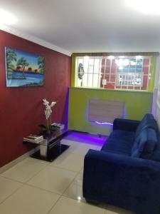 a living room with a blue couch and a window at Pinto City Motel in Kempton Park