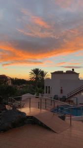 puesta de sol sobre un edificio con piscina en Apartamentos Villa Aurora, en Valle Gran Rey