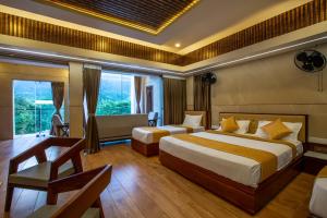 a hotel room with two beds and a desk at Zamin Resort in Kuttālam