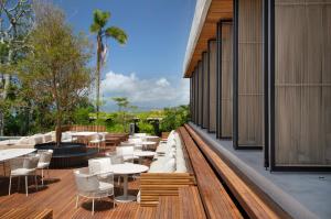 um deque com mesas e cadeiras num edifício em Fuso Concept Hotel em Florianópolis