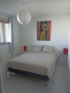- une chambre avec un lit et une photo sur le mur dans l'établissement Appartement 2 pièces + cabine, 6 couchages, au Grau-du-Roi