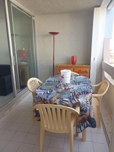 une table à manger avec des chaises et une table avec dans l'établissement Appartement 2 pièces + cabine, 6 couchages, au Grau-du-Roi