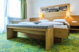 a bedroom with a large wooden bed in a room at Alpinhotel Maistatt in Schladming