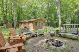 a group of chairs and a fire pit in front of a cabin at Secluded Farwell Cabin with Fire Pit and Gas Grill! in Lake
