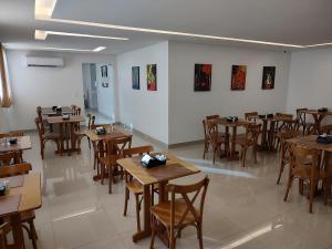 a dining room with wooden tables and chairs at Hotel Jucazinho in Surubim