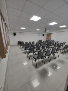 an empty room with rows of chairs in a room at Hotel Jucazinho in Surubim