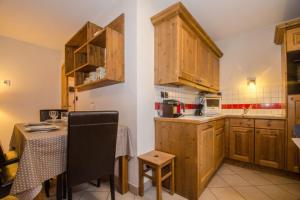 una cocina con armarios de madera y una mesa pequeña con una mesa. en Cosy cocoon in the heart of Chamonix, en Chamonix-Mont-Blanc