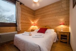 Un dormitorio con una cama con paredes de madera y una ventana en Cosy cocoon in the heart of Chamonix, en Chamonix-Mont-Blanc