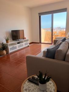 sala de estar con sofá y TV de pantalla plana en Apartamento Eulália, en Albufeira