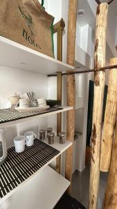 uma cozinha com prateleiras com tigelas e utensílios em Squisita Home em Noto