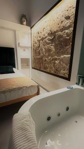 uma casa de banho com uma banheira ao lado de uma cama em Squisita Home em Noto