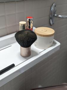 a brush sitting on a shelf in a bathroom at Fuzei Hôtel Lorient-Lanester in Lanester