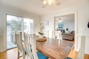 a dining room with a wooden table and chairs at Elegant Tybee Island Townhome, Steps to Beach in Tybee Island