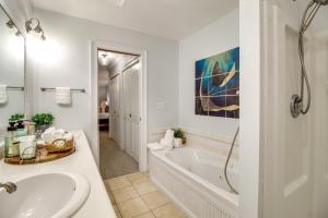 Baño blanco con bañera y lavamanos en Elegant Tybee Island Townhome, Steps to Beach en Tybee Island