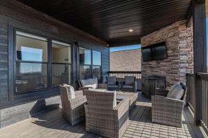 a patio with wicker chairs and a fireplace on a building at Modern Rustic in Branson
