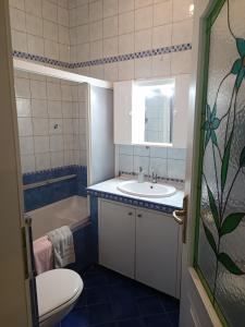 La salle de bains est pourvue d'un lavabo, de toilettes et d'une baignoire. dans l'établissement Apartma MOST, à Kanal