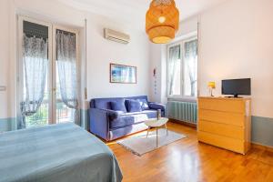una camera da letto con divano blu e TV di Praedia a Scafati