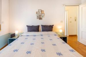 una camera da letto con un grande letto bianco con cuscini blu di Praedia a Scafati