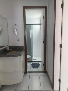 a bathroom with a toilet and a sink and a shower at apartamento em edifício de frente para o mar na praia do morro Guarapari in Guarapari