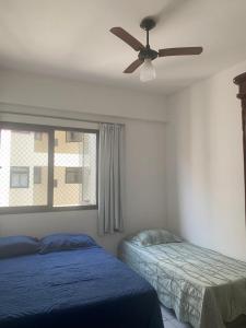 a bedroom with two beds and a ceiling fan at apartamento em edifício de frente para o mar na praia do morro Guarapari in Guarapari