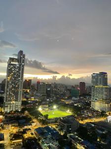 een skyline van de stad 's nachts met een groen veld bij Mercu Summer Suites KLCC By Minutepointhome in Kuala Lumpur