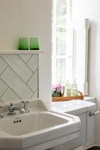 a white sink in a bathroom with a window at The Queens Arms in Sherborne