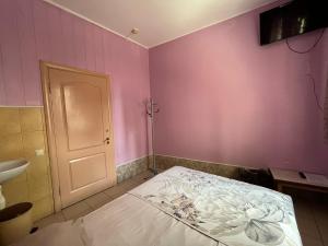 Pokój z łóżkiem w pokoju z różowymi ścianami w obiekcie Sun w Chmielnickim