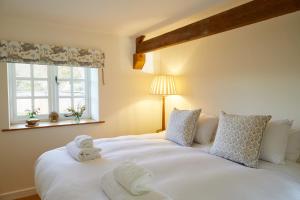 a bedroom with a large white bed with towels on it at The Queens Arms in Sherborne
