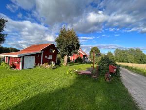 a red barn on the side of a road at Lavendeltorpet in Häggum